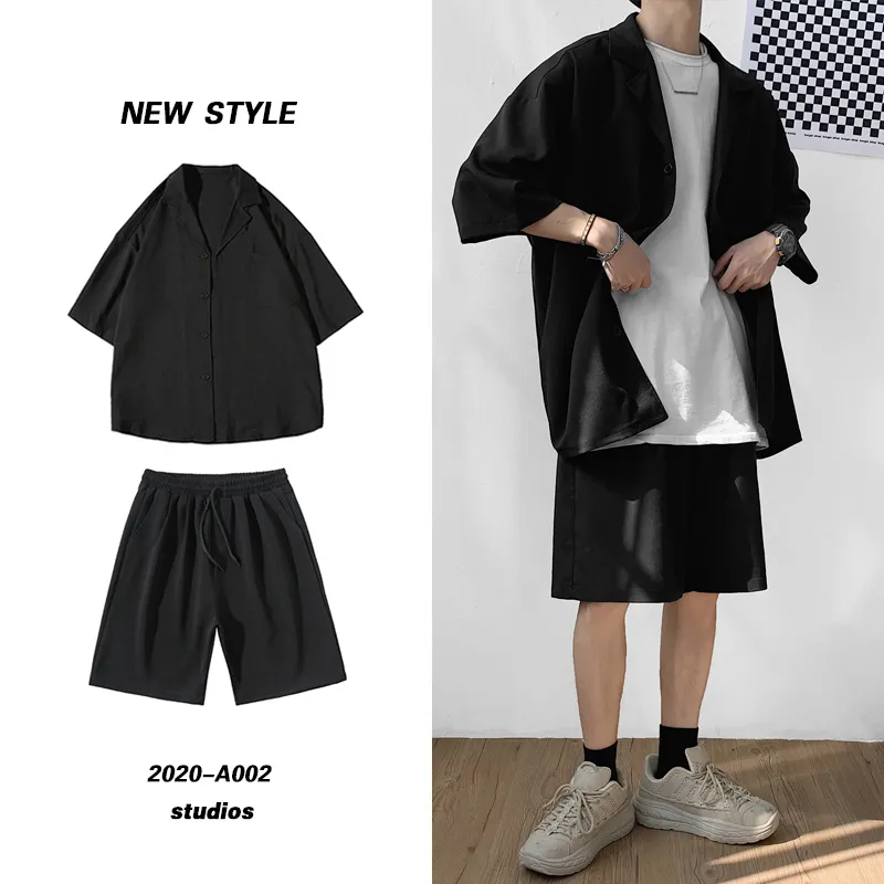 Black oversized button-up shirt and matching shorts displayed beside a standing model wearing the set.