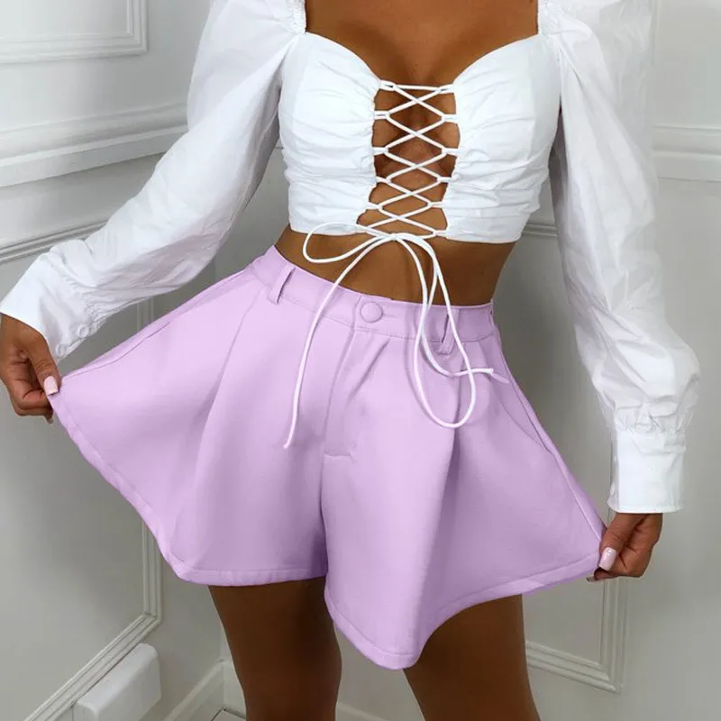 A model wearing light purple high-waisted ruffle shorts while holding the flared hems outward.
