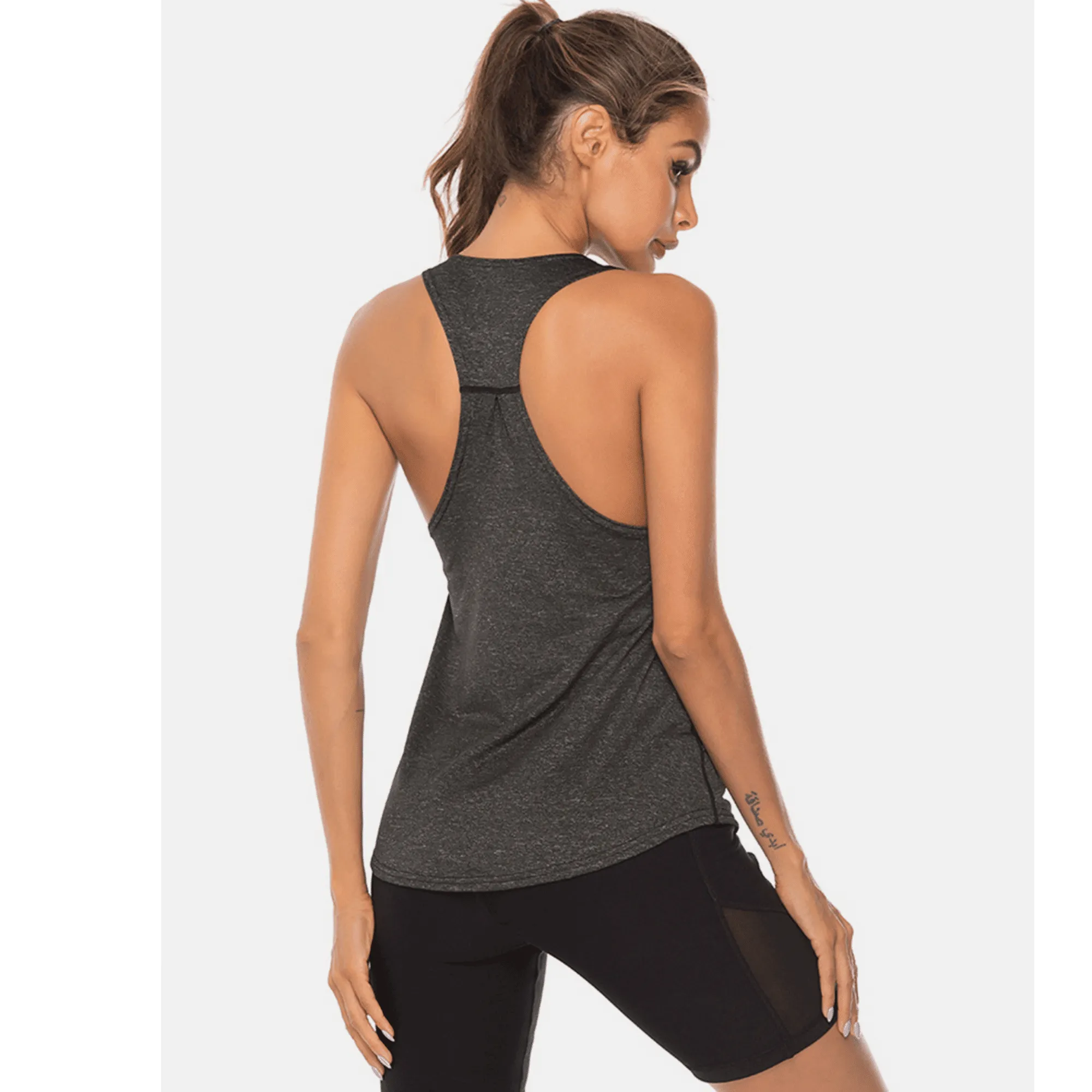 Back angled view of a charcoal long workout tank top with racerback straps.