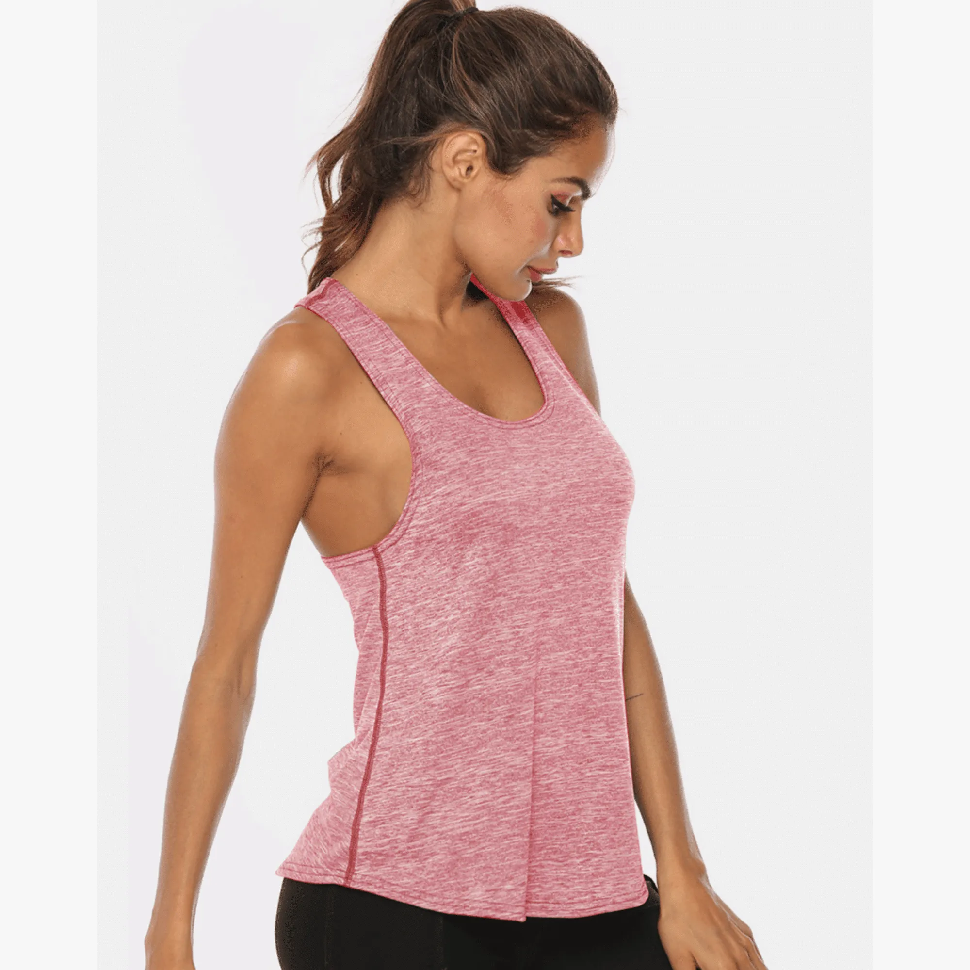 Profile view of a model in a rose-pink long workout tank top.