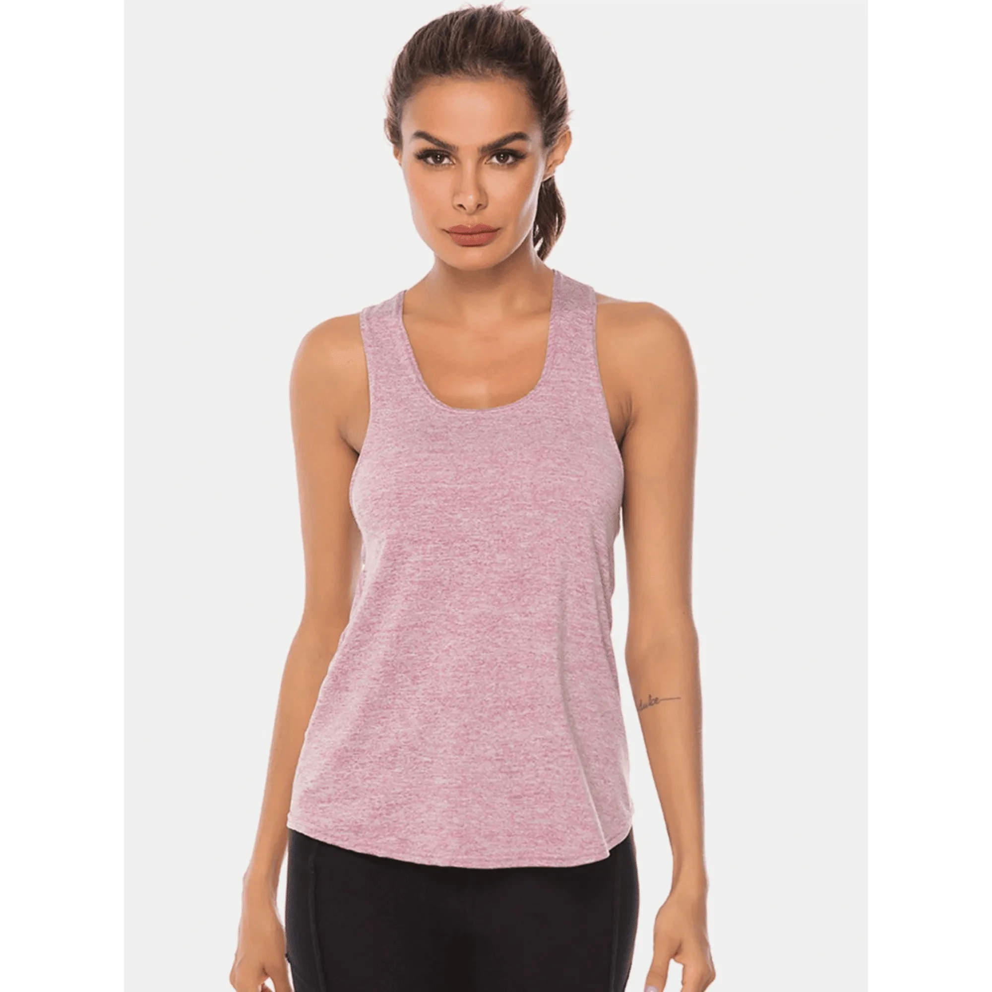 Model wearing a light pink long scoop-neck workout tank top from the front.