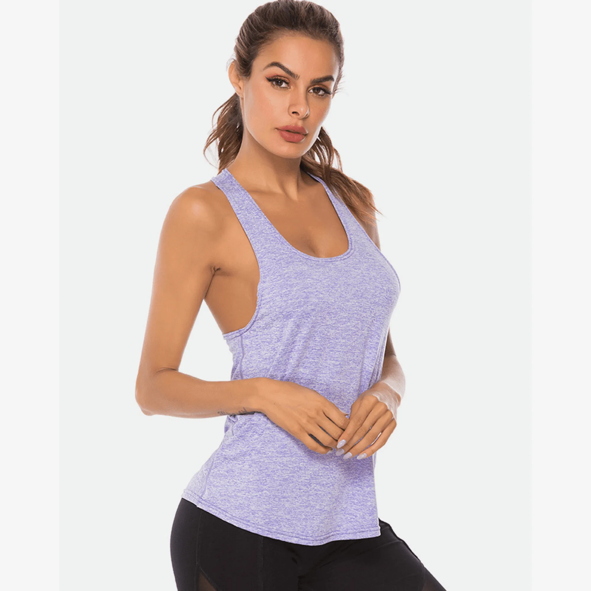 Model wearing a lavender long scoop-neck workout tank top in a front angled pose.