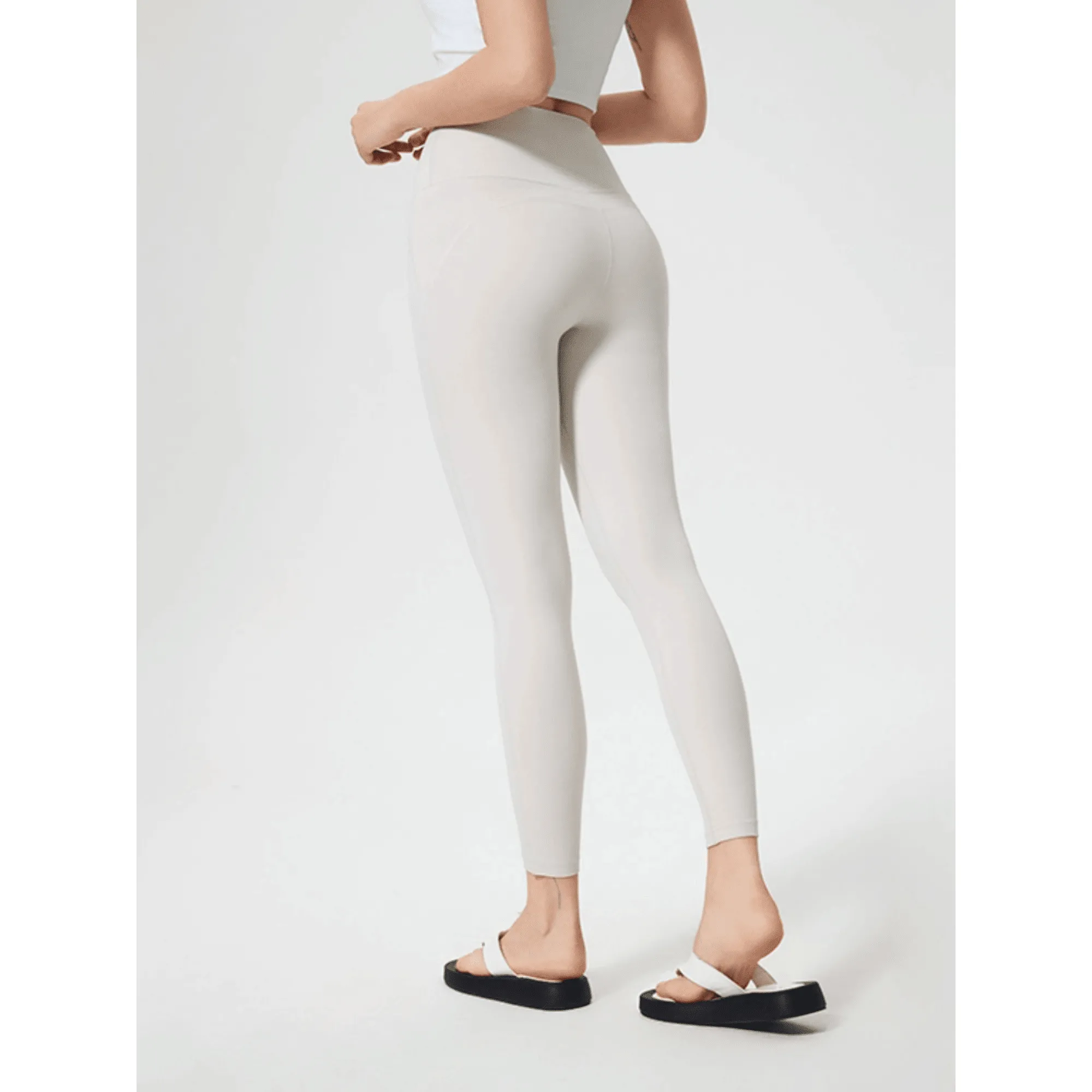 White workout leggings shown from an angled rear view on a model.