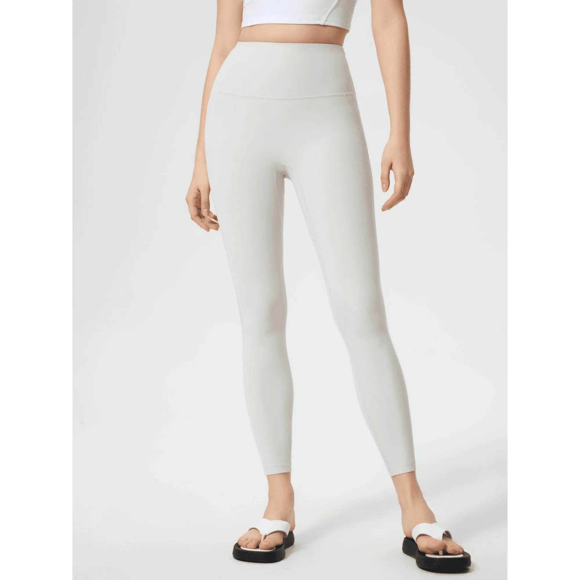 White workout leggings shown from the front with a wide high-rise waistband.