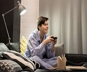 Young Man Playing Video Games In Pajamas